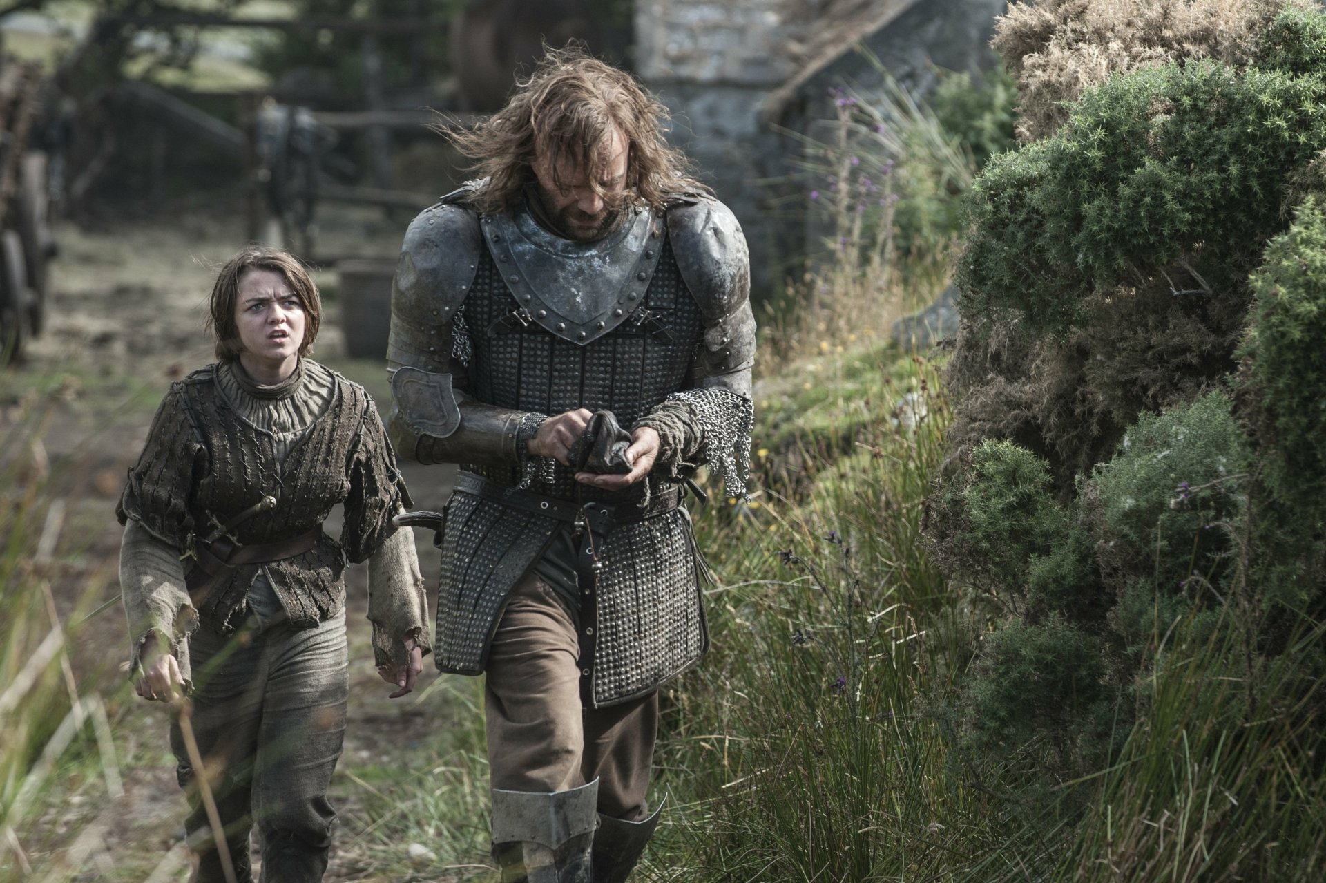 Rory McCann as Sandor Clegane and Maisie Williams as Arya Stark walking together in a scenic landscape from the TV show Game of Thrones, captured in vibrant 4K Ultra HD.
