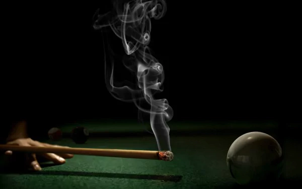 A dramatic HD wallpaper featuring a close-up of a cue stick, smoke curling above it, and a billiard ball on a green pool table, capturing the essence of a game of pool.