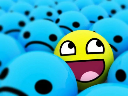 A humorous HD PC desktop wallpaper featuring a single bright yellow smiley face with a goofy expression among many blue sad-faced spheres.