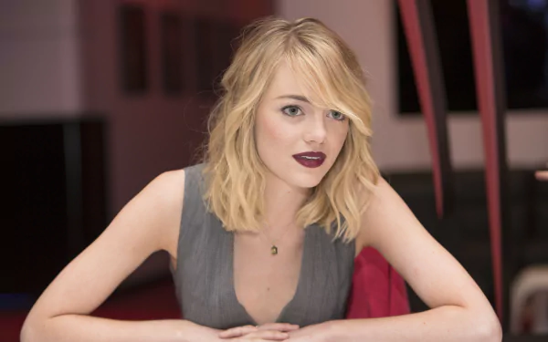 4K Ultra HD image of celebrity Emma Stone with blonde hair and dark lipstick, set against a blurred indoor background, designed as a PC desktop wallpaper.