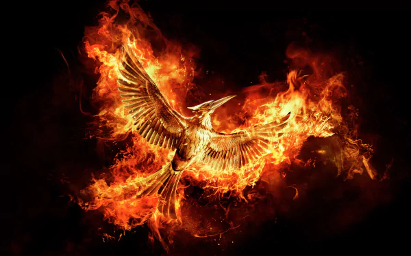A striking HD wallpaper from *The Hunger Games: Mockingjay - Part 2*, featuring a fiery phoenix soaring through flames, symbolizing rebellion and resilience.