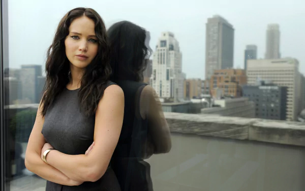 4K Ultra HD PC desktop wallpaper featuring celebrity Jennifer Lawrence standing with arms crossed by a window overlooking a cityscape.