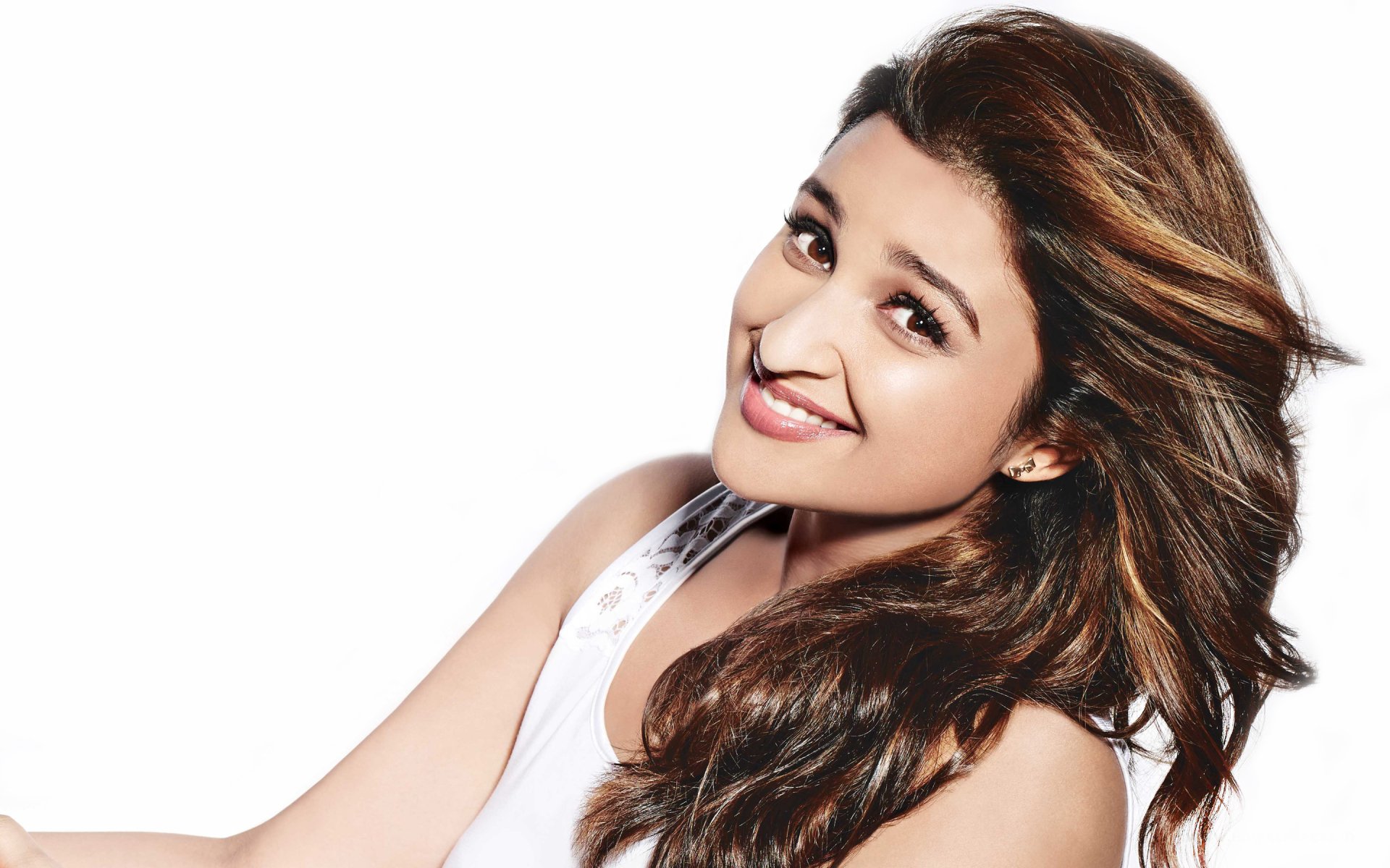 A stunning HD wallpaper featuring celebrity Parineeti Chopra, smiling brightly with flowing hair, set against a clean white background.