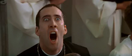 Nicolas Cage in a dramatic scene from the movie *Face/Off*, showcasing intense emotion with a wide-open mouth and striking eyes, set as a captivating HD desktop wallpaper.