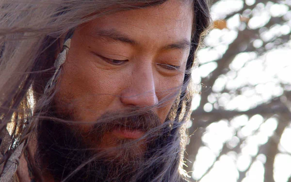 Close-up of a bearded warrior from the movie Mongol: The Rise of Genghis Khan, wind-blown hair and contemplative gaze; HD PC desktop wallpaper and background.