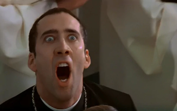 Nicolas Cage in a dramatic scene from the movie *Face/Off*, showcasing intense emotion with a wide-open mouth and striking eyes, set as a captivating HD desktop wallpaper.