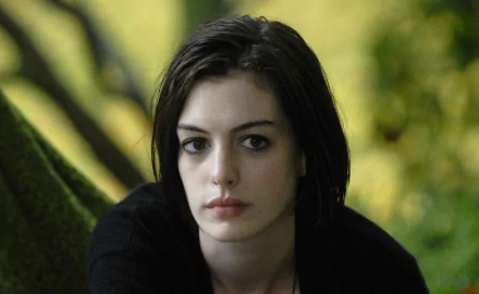 HD desktop wallpaper featuring Anne Hathaway in a scene from the movie Rachel Getting Married, set against a softly blurred natural background.