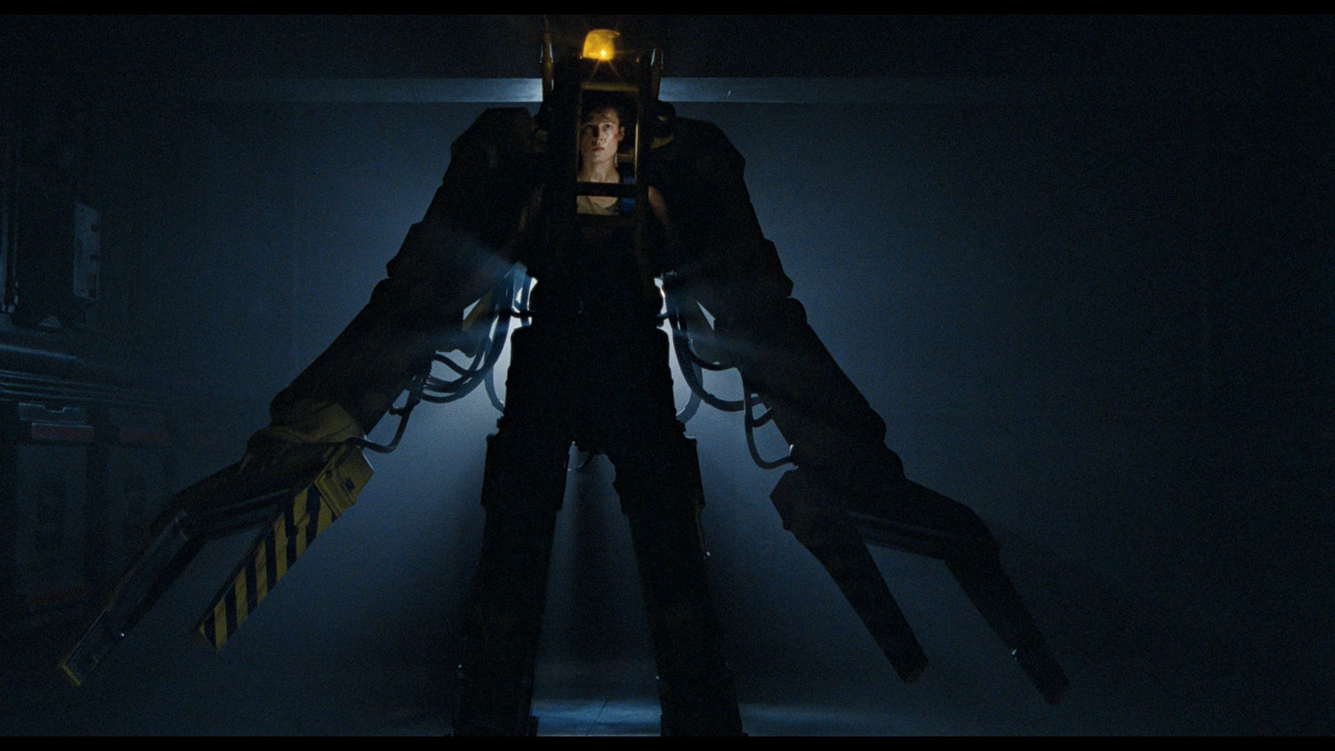 Movie alien HD PC desktop wallpaper: silhouetted figure in a bulky mechanized suit with oversized hydraulic arms, backlit in a dark industrial corridor.