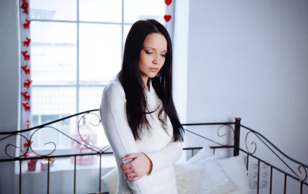 A 4K Ultra HD PC desktop wallpaper featuring a woman, Angelina Petrova, standing thoughtfully in a bright, softly lit room with red heart decorations.