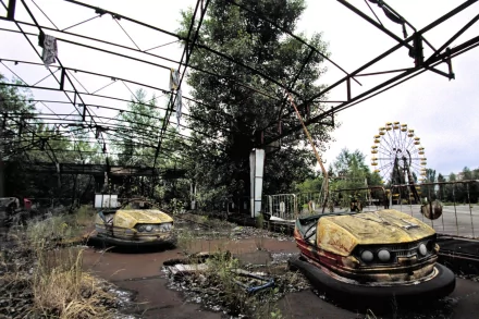 The HD wallpaper depicts the abandoned Pripyat Amusement Park in Chernobyl, featuring deteriorated bumper cars and a rusted Ferris wheel surrounded by overgrown vegetation and a skeletal ride structure.