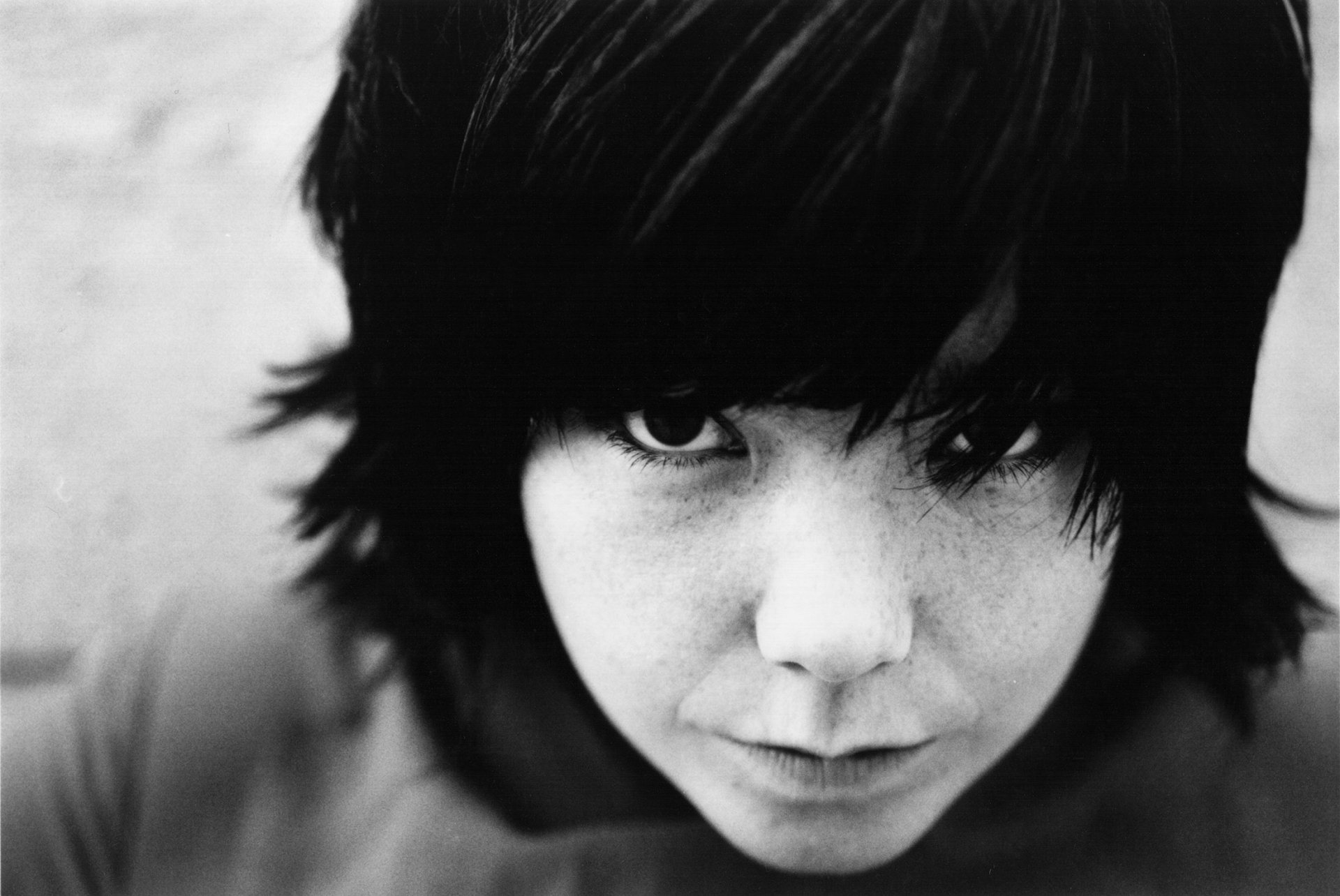 Black and white close-up portrait of Björk with dark hair, captured in a high-definition image for a PC desktop wallpaper background.