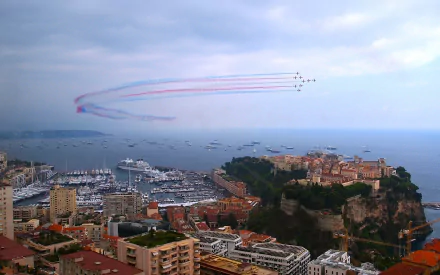 2K Quad HD PC desktop wallpaper and background: military jets perform an air show over a coastal city and marina, leaving red, white and blue smoke trails above a rocky promontory.