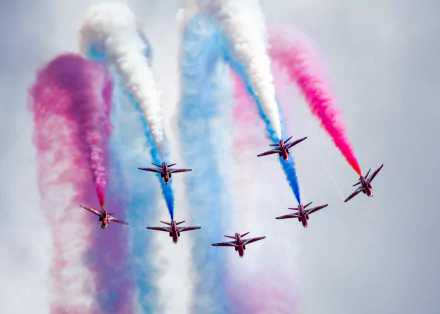 A 4K Ultra HD desktop wallpaper showing military jets performing a colorful air show with red, white, and blue smoke trails against a clear sky.