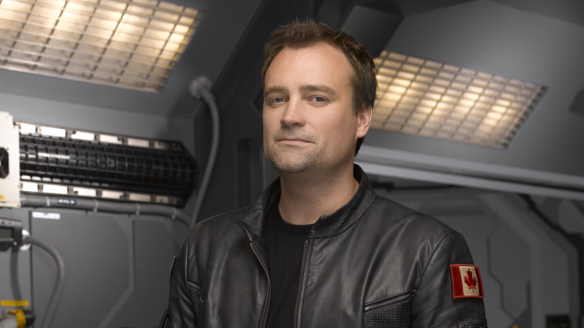 HD PC desktop wallpaper featuring a character from the TV show Stargate Atlantis in a futuristic setting.