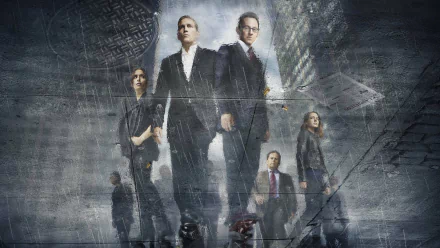 A dramatic HD wallpaper featuring the main characters from Person of Interest: Sarah Shahi, Kevin Chapman, Amy Acker, Jim Caviezel, and Michael Emerson, set against a gritty urban backdrop.
