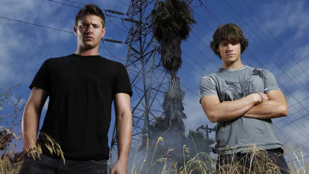 HD wallpaper featuring characters from the TV show Supernatural, standing confidently in front of a power line against a dramatic sky.