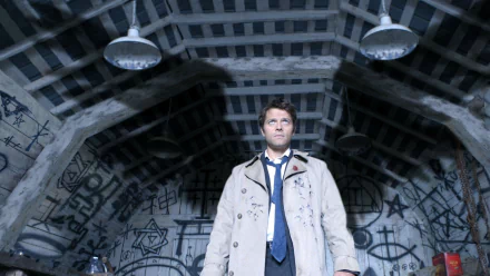 HD wallpaper depicting a scene from the TV show Supernatural with a character standing in a room covered in symbols and dim lighting.