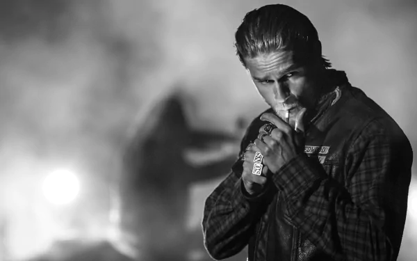 Black-and-white HD desktop wallpaper featuring a brooding character from the TV show Sons of Anarchy, lighting a cigarette with a smoky, intense background.