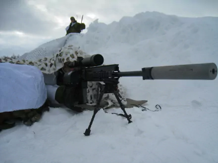 HD desktop wallpaper showing a military sniper positioned in snowy terrain, aiming through a camouflaged rifle with a suppressor attached.