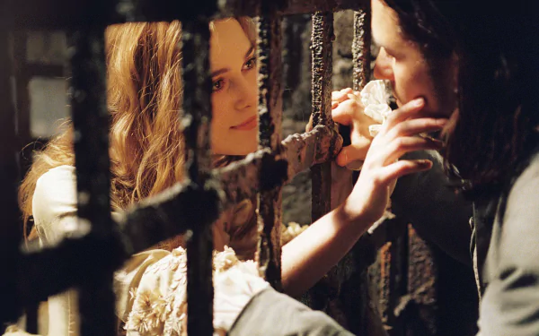 Elizabeth Swann (Keira Knightley) and Will Turner (Orlando Bloom) share a tender moment through prison bars in a scene from Pirates of the Caribbean: Dead Man's Chest.