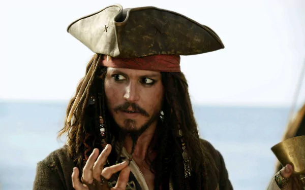 Jack Sparrow, portrayed by Johnny Depp, in a scene from Pirates of the Caribbean: Dead Man's Chest. The HD wallpaper captures the iconic pirate in a dramatic pose against a watery backdrop.