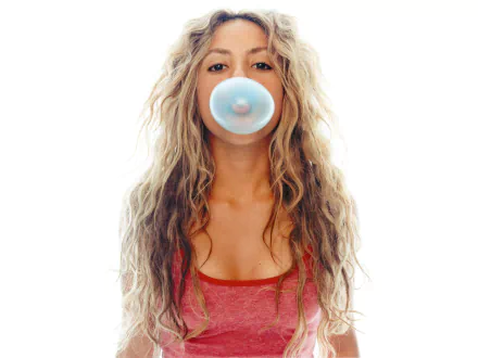 A vibrant HD desktop wallpaper featuring Shakira blowing a bubble with gum, showcasing her playful spirit and stunning curly hair against a clean white background.