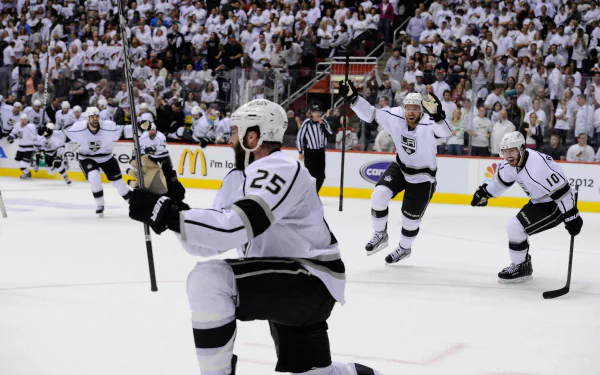 HD PC desktop wallpaper featuring Los Angeles Kings hockey players celebrating on the ice during a high-energy game in front of a packed crowd.