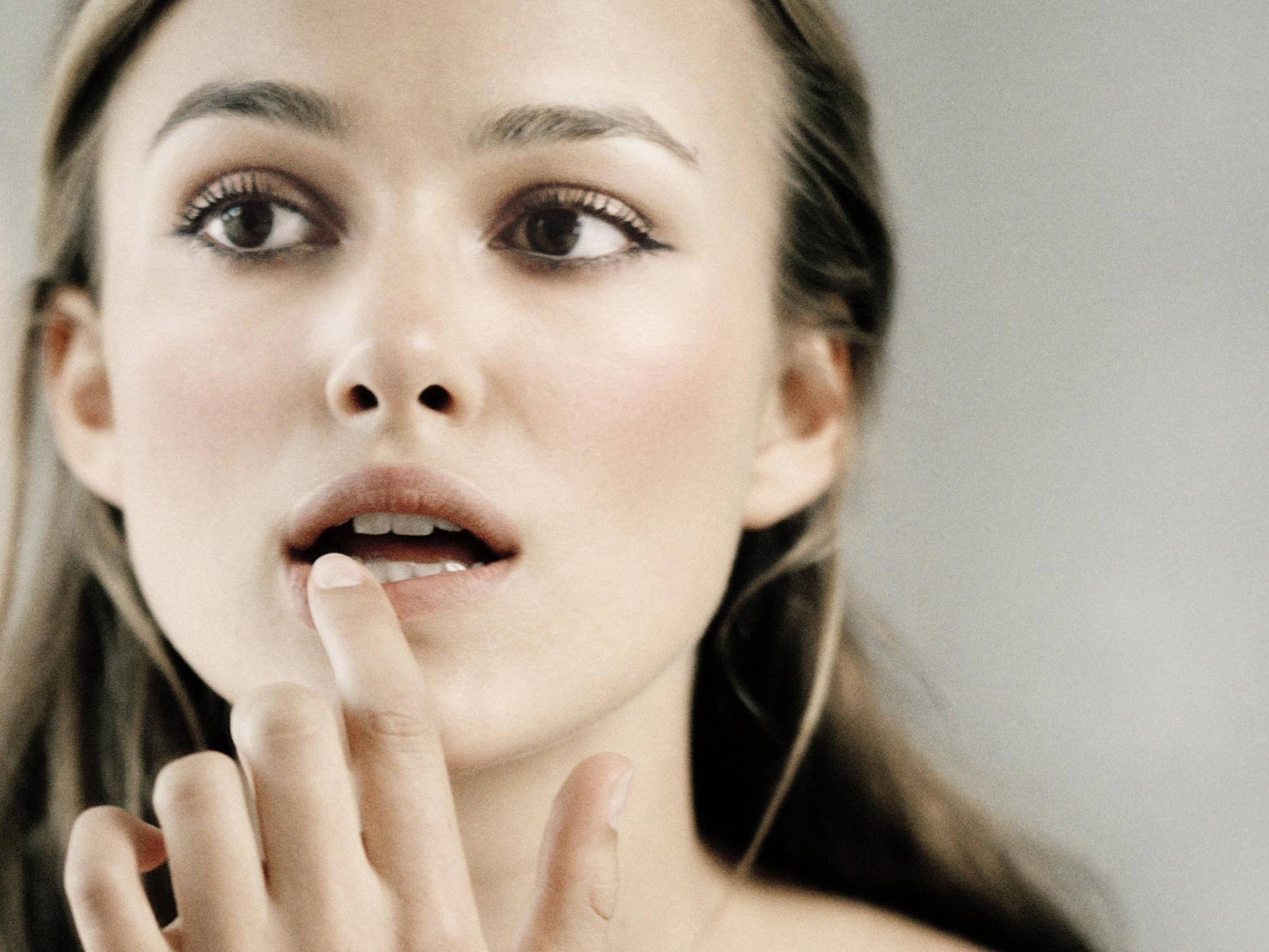 HD PC desktop wallpaper featuring a close-up portrait of celebrity Keira Knightley with a soft, natural expression against a light background.