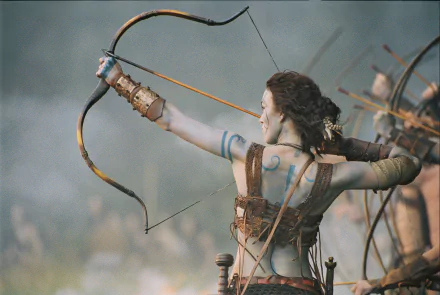 Keira Knightley aiming a bow in a scene from the movie King Arthur, captured in a detailed HD PC desktop wallpaper.