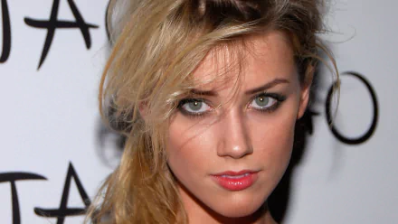A striking HD wallpaper featuring celebrity Amber Heard, showcasing her captivating gaze and defined features against a simple background.