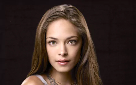 HD PC desktop wallpaper featuring celebrity Kristin Kreuk with a dark background, highlighting her natural beauty and serene expression.