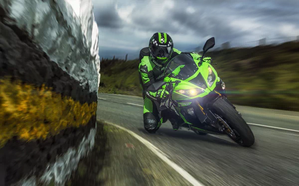 HD PC desktop wallpaper featuring a Kawasaki Ninja motorcycle speeding along a winding road, with motion blur highlighting its dynamic performance.