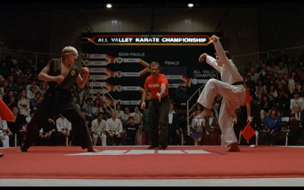 HD desktop wallpaper from the movie The Karate Kid (1984) showing the climactic All Valley Karate Championship match between two competitors in a crowded arena.