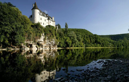 Chateau de la Treyne on cliffs above a reflective river, surrounded by green hills — 2K Quad HD man-made PC desktop wallpaper/background.
