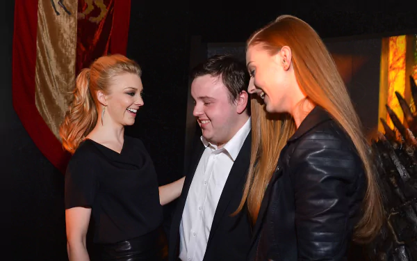 HD PC desktop wallpaper featuring actors Sophie Turner, John Bradley, and Natalie Dormer sharing a moment together in a warmly lit setting.