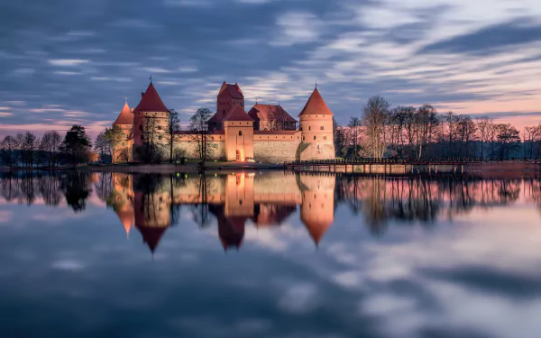 Trakai Island Castle in Lithuania at sunset, medieval towers reflected on a calm lake — HD man-made castle desktop wallpaper.