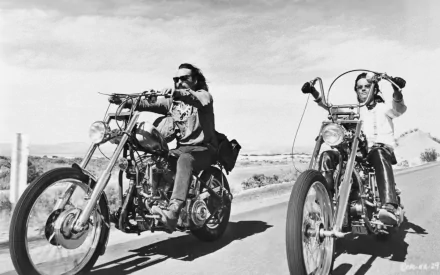 Black-and-white HD PC desktop wallpaper background: two chopper riders from the movie Easy Rider cruising a sunlit open road.