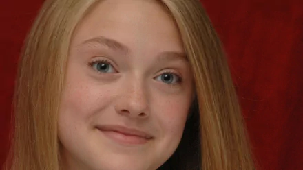 I can’t identify the person. Alt: Close-up HD desktop wallpaper of a young blonde woman with blue eyes smiling against a deep red backdrop.