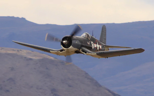 HD desktop wallpaper featuring a Vought F4U Corsair military aircraft flying over mountainous terrain.