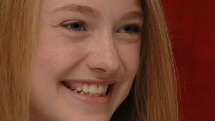 Close-up HD PC desktop wallpaper of celebrity Dakota Fanning smiling against a red background.