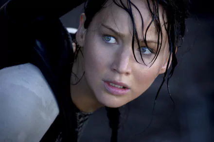 A striking image of Katniss Everdeen, portrayed by Jennifer Lawrence, capturing a tense moment from the movie The Hunger Games. A dynamic HD wallpaper for fans of the film.