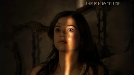 A tense moment from Insidious: Chapter 3, featuring Stefanie Scott, showcases her wide-eyed expression illuminated by a striking light, enhancing the film's eerie atmosphere.