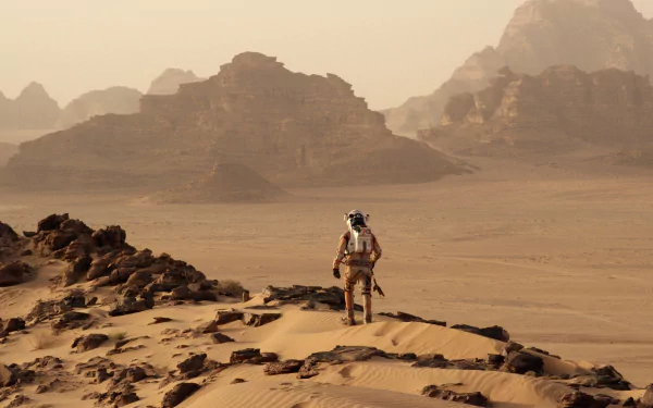 An astronaut explores the desolate Martian landscape in this stunning 4K Ultra HD wallpaper inspired by the movie The Martian. Dramatic mountains rise in the background.