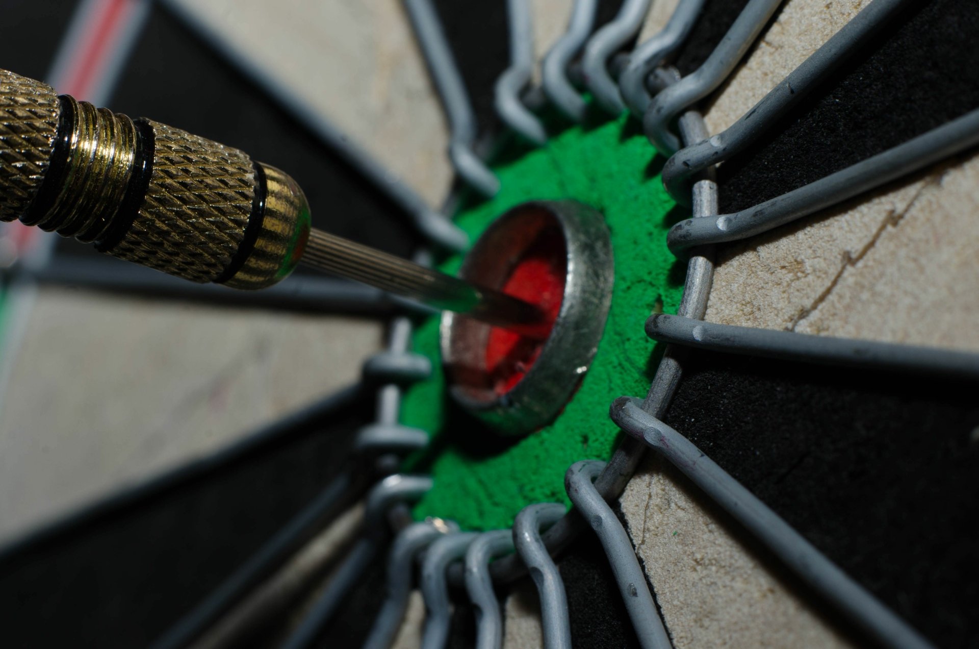 Close-up of a dart hitting the bullseye on a man-made dartboard, captured in sharp detail for a 4K Ultra HD PC desktop wallpaper and background.