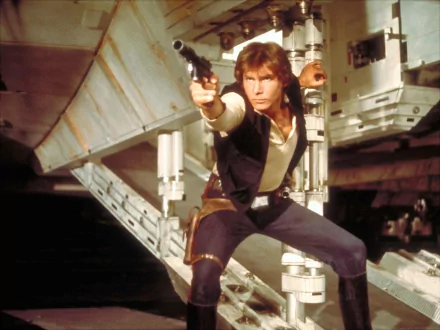 Han Solo, poised with a blaster, strikes a confident pose against the backdrop of the Millennium Falcon. This HD wallpaper captures the iconic essence of the Star Wars movie series.