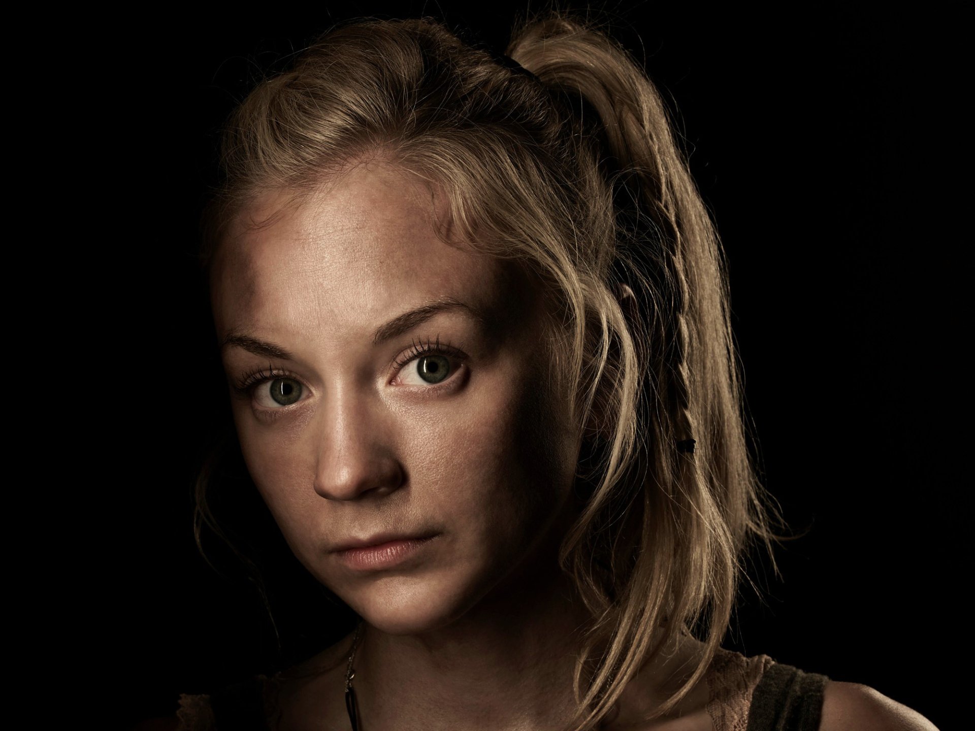 A close-up of actress Emily Kinney as Beth Greene from the TV show The Walking Dead, featuring a dramatic expression against a dark background. HD wallpaper quality.