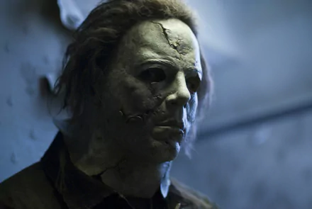 HD desktop wallpaper featuring Michael Myers from the movie Halloween II (2009), showcasing his iconic stitched mask in a dimly lit setting.