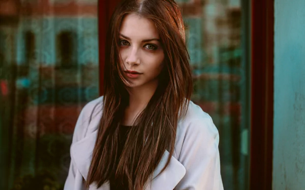 Portrait of a brunette woman with brown eyes, captured in 4K Ultra HD, standing against an urban backdrop, exuding a calm and confident presence.