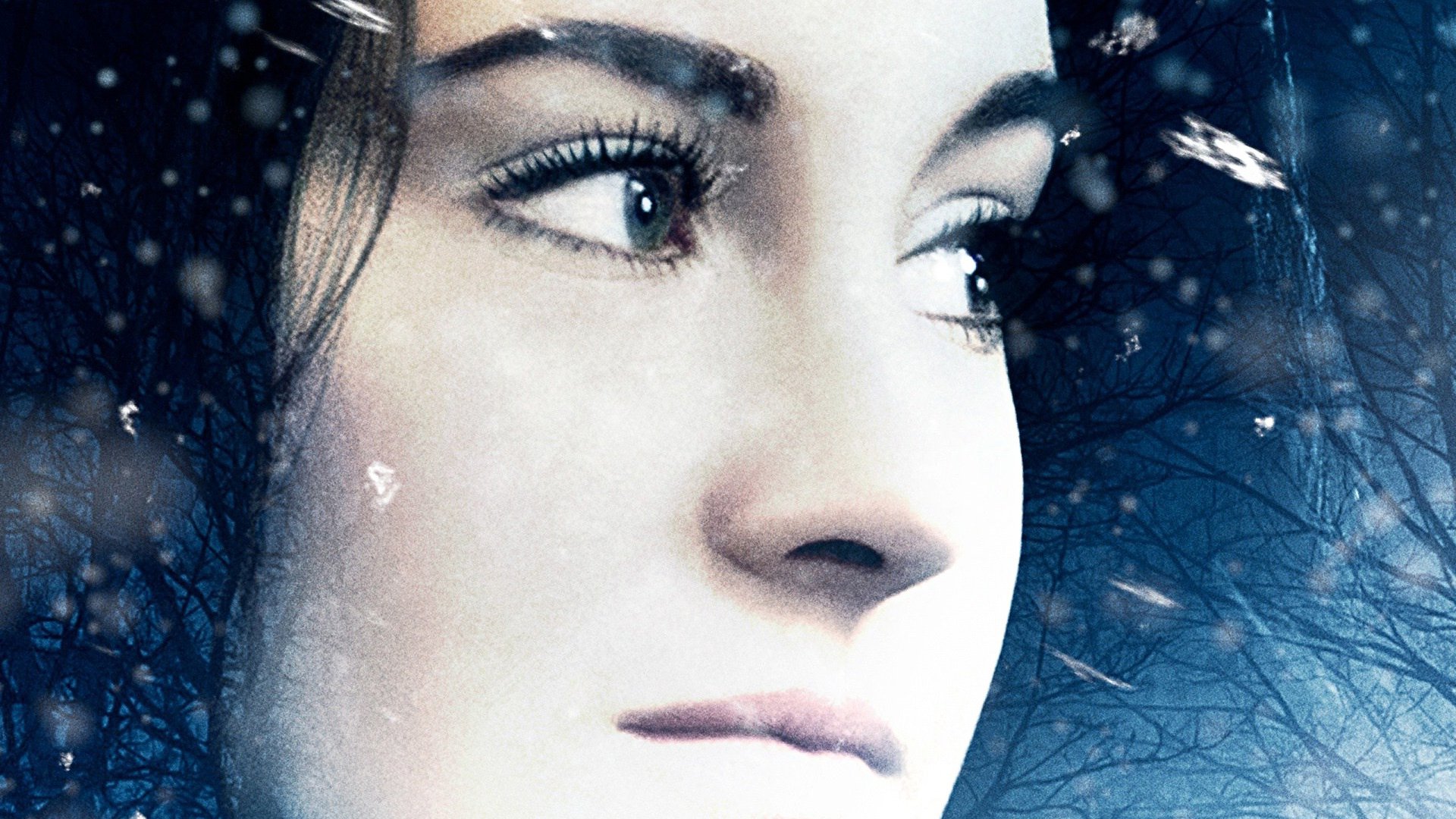 Close-up of a woman's face from the movie White Bird in a Blizzard, dusted with snowflake overlay and cool blue tones — HD PC desktop wallpaper.