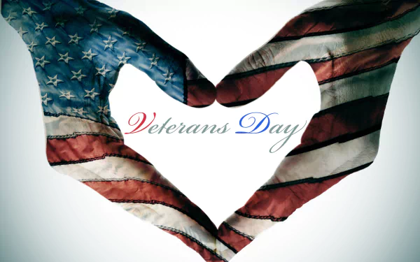 Hands painted with the American flag form a heart around Veterans Day script — 4K Ultra HD PC desktop wallpaper and holiday Veterans Day background.